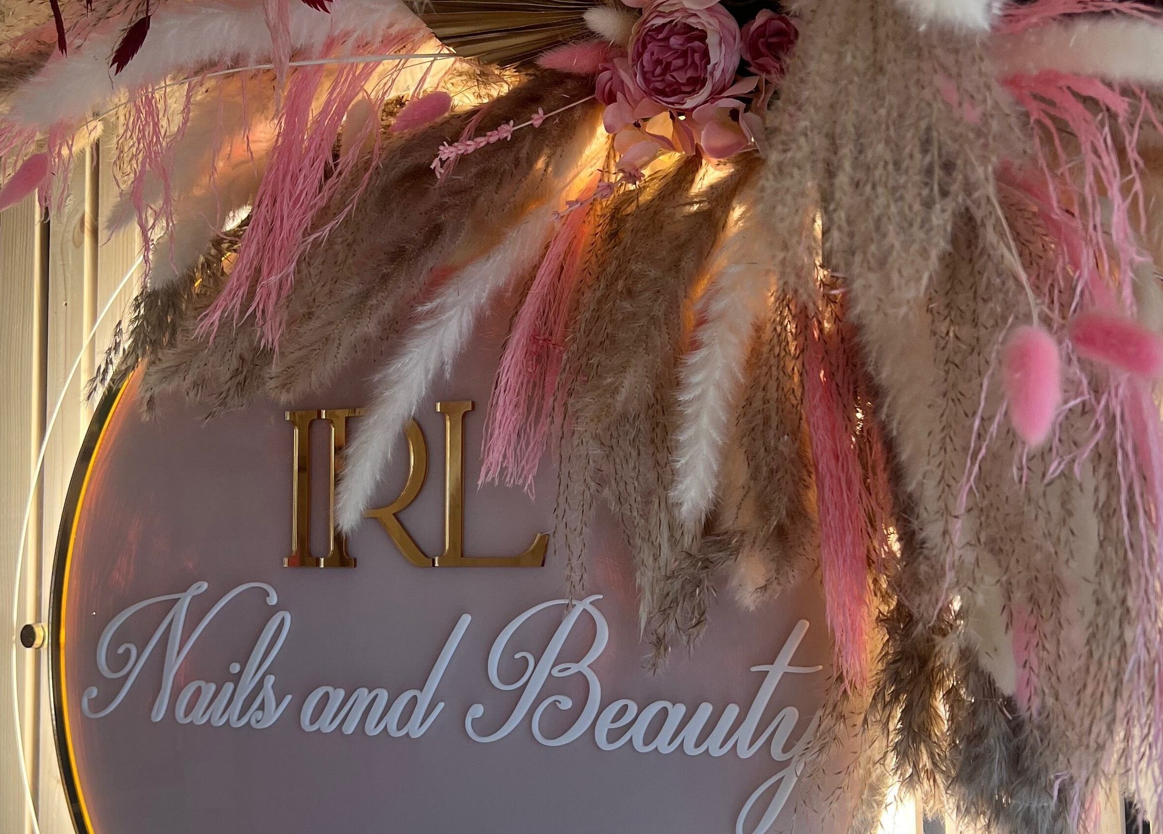 Floral decor at IRL Nails and Beauty, Leicester, England, GB. Elegant branding signage surrounded by pink florals.