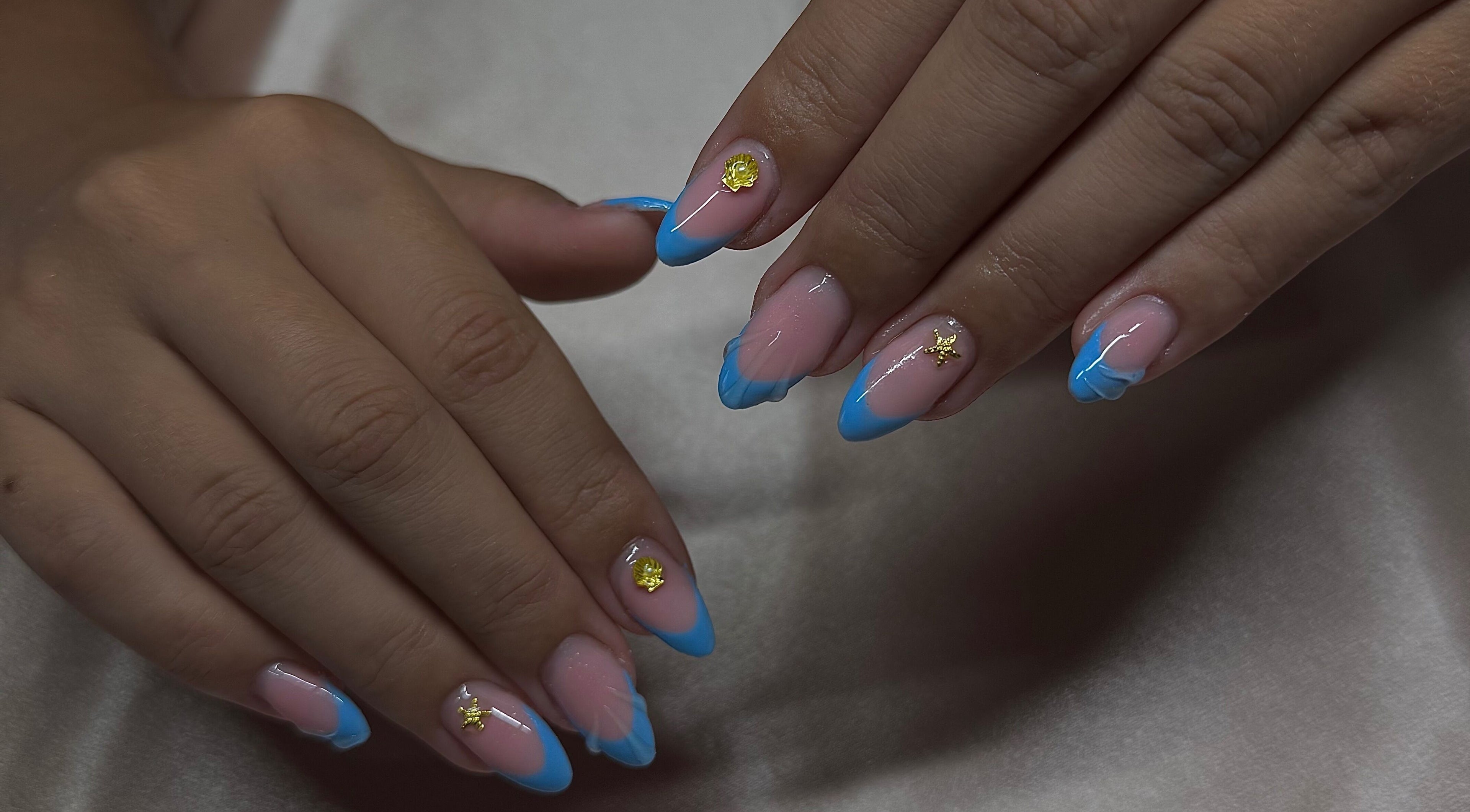 Design d'ongles bleus avec décorations dorées à Nails by Andréa, Priay, Auvergne-rhône-alpes, FR.