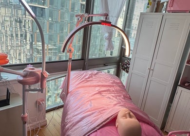 Relaxing facial treatment setup at Bare Facials By Bibi, New York, New York, US with pink decor and modern equipment.