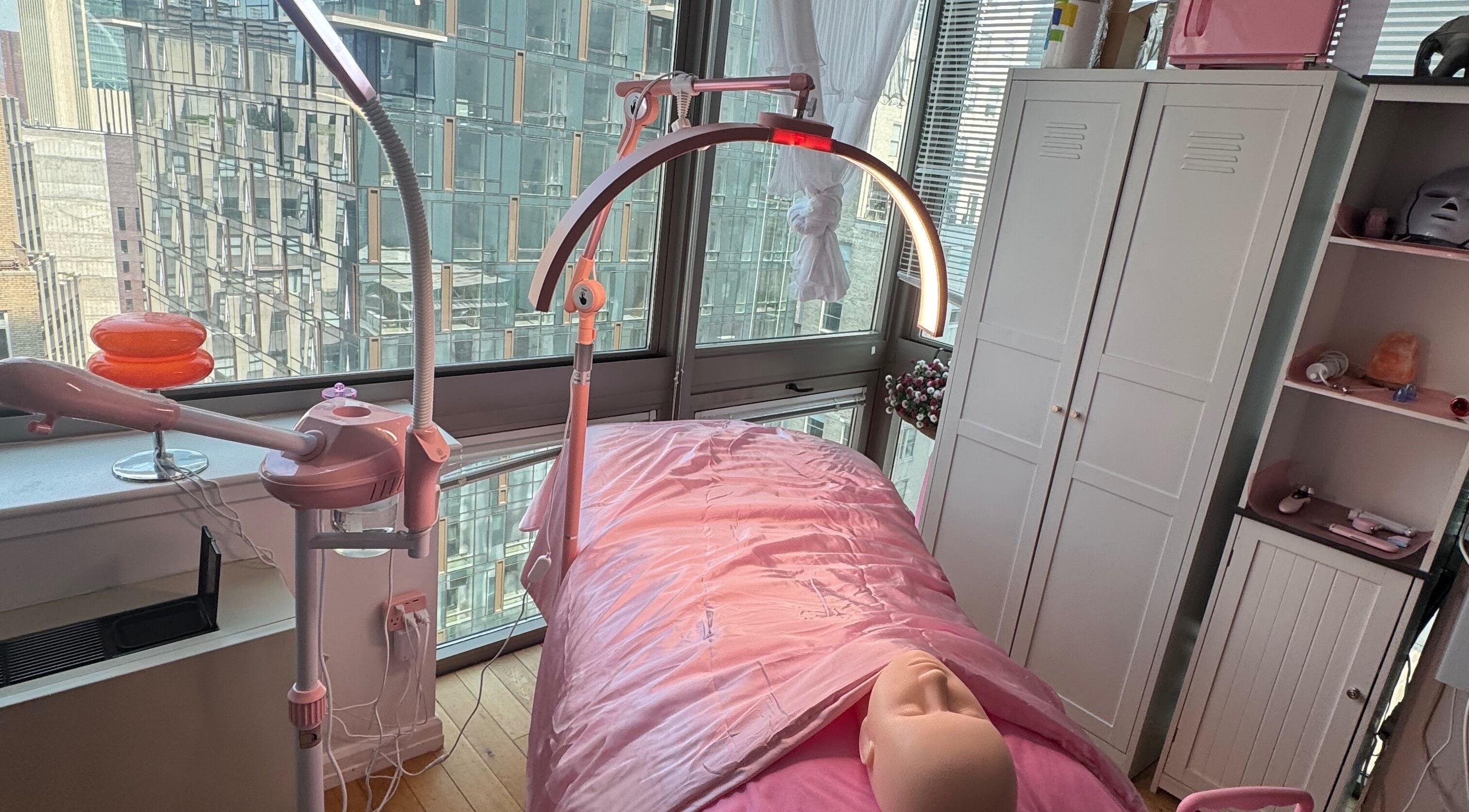 Relaxing facial treatment setup at Bare Facials By Bibi, New York, New York, US with pink decor and modern equipment.
