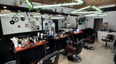 Interior de Astu Barber, Pérez, Santa Fe, AR, con sillas y espejos decorados con plantas.