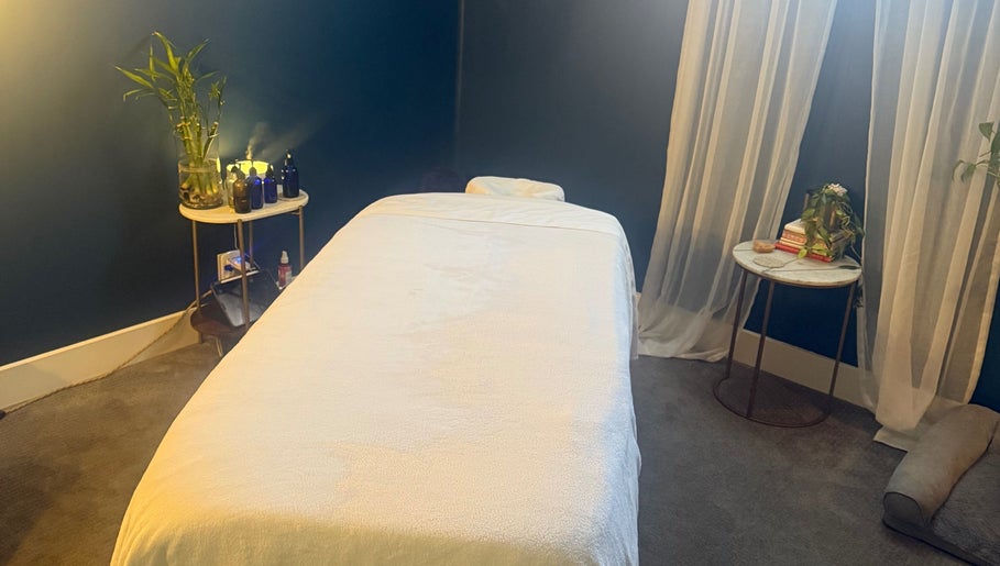 Tranquil massage room at Be Well Bozeman, Bozeman, Montana, US, featuring a cozy bed and ambient lighting.