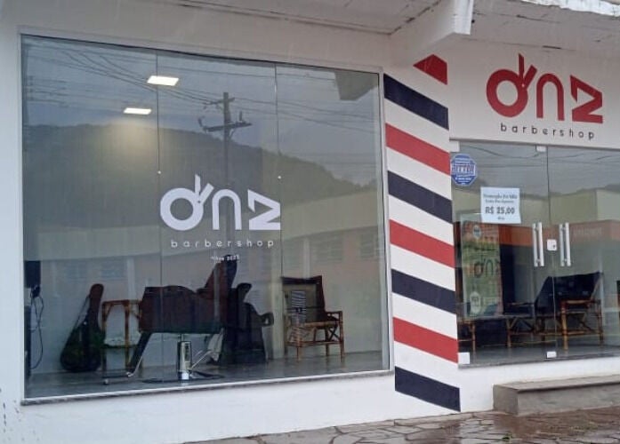 Fachada moderna do DnZ Barbershop em Rio Grande Do Sul, Brasil, com decoração de listras coloridas.