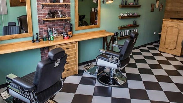 Κομψό εσωτερικό του The Barbershop Club στην Ηράκλειο, GR με καρέκλες και καθρέφτες.