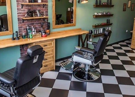 Κομψό εσωτερικό του The Barbershop Club στην Ηράκλειο, GR με καρέκλες και καθρέφτες.