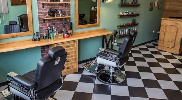 Κομψό εσωτερικό του The Barbershop Club στην Ηράκλειο, GR με καρέκλες και καθρέφτες.