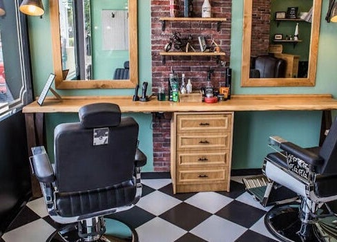 Άνετη αίθουσα στο The Barbershop Club, Ηράκλειο, GR με κλασικές καρέκλες και μοντέρνα διακόσμηση.