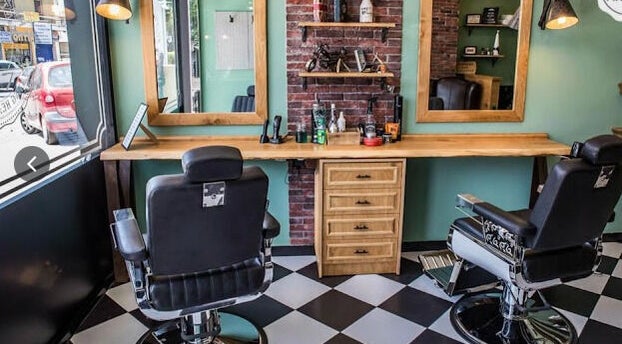 Άνετη αίθουσα στο The Barbershop Club, Ηράκλειο, GR με κλασικές καρέκλες και μοντέρνα διακόσμηση.