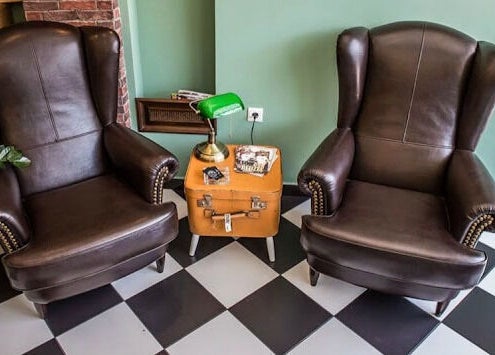 Δύο άνετες πολυθρόνες στο The Barbershop Club, Ηράκλειο, GR με vintage διακόσμηση.