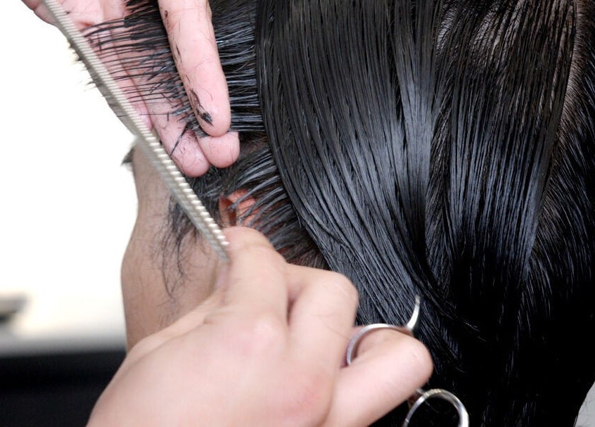 A stylist cuts hair at Whistle & Flute Barber Studio, Auckland, Auckland, NZ, showcasing expert hair techniques.