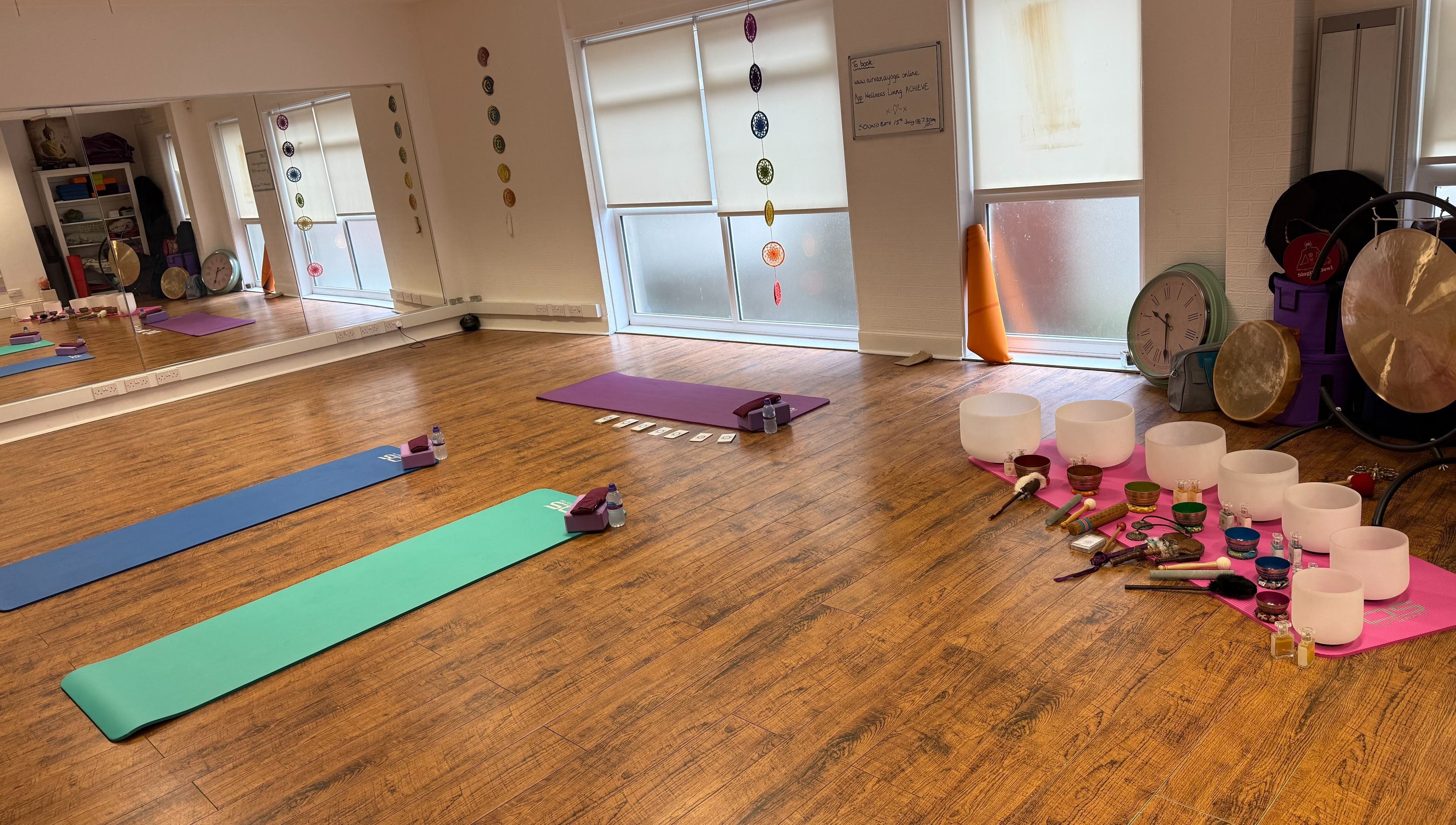 Peaceful yoga studio at Dhyan Jyoti-Eir, Lanark, Scotland, GB with mats, singing bowls, and gongs for meditation.