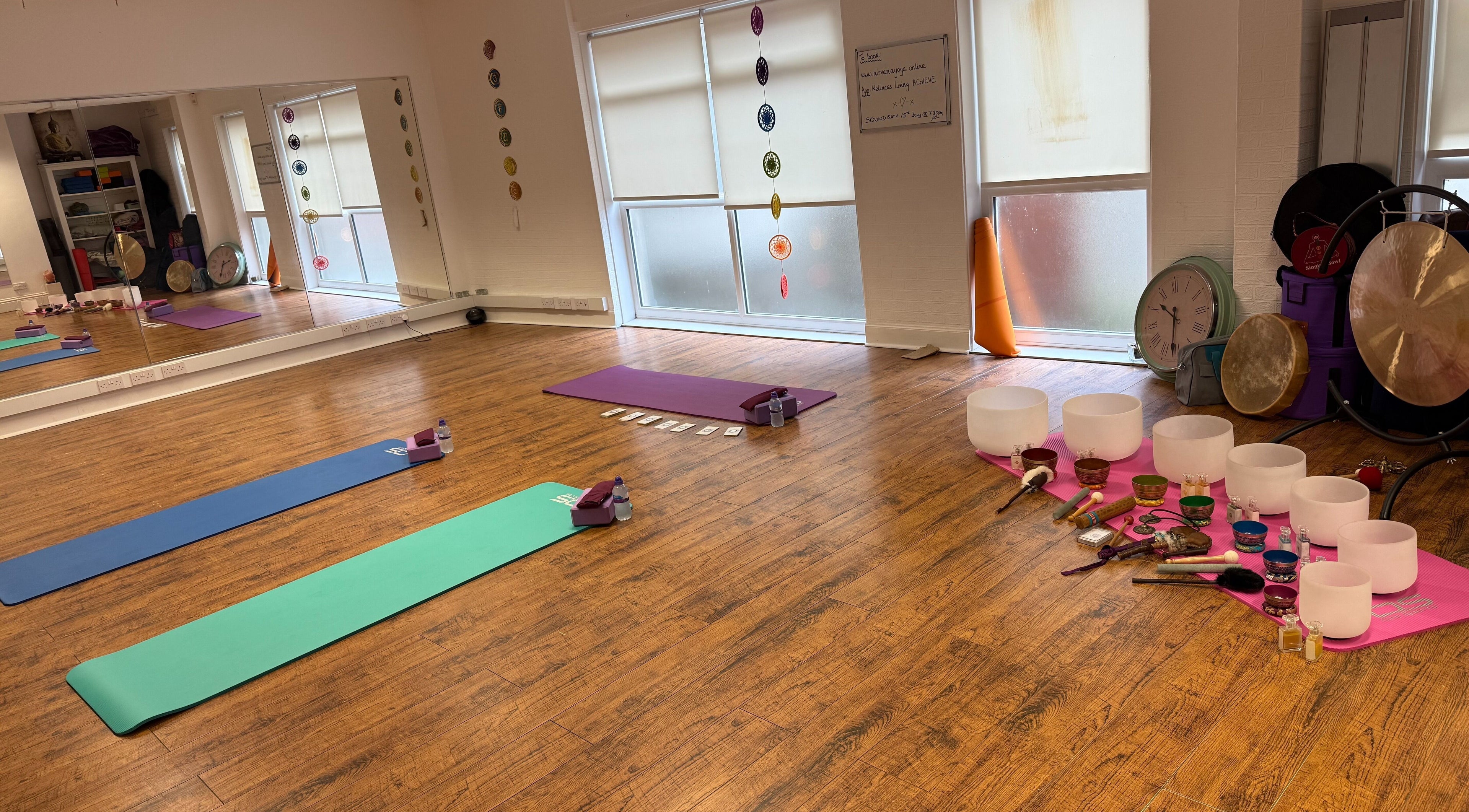 Peaceful yoga studio at Dhyan Jyoti-Eir, Lanark, Scotland, GB with mats, singing bowls, and gongs for meditation.