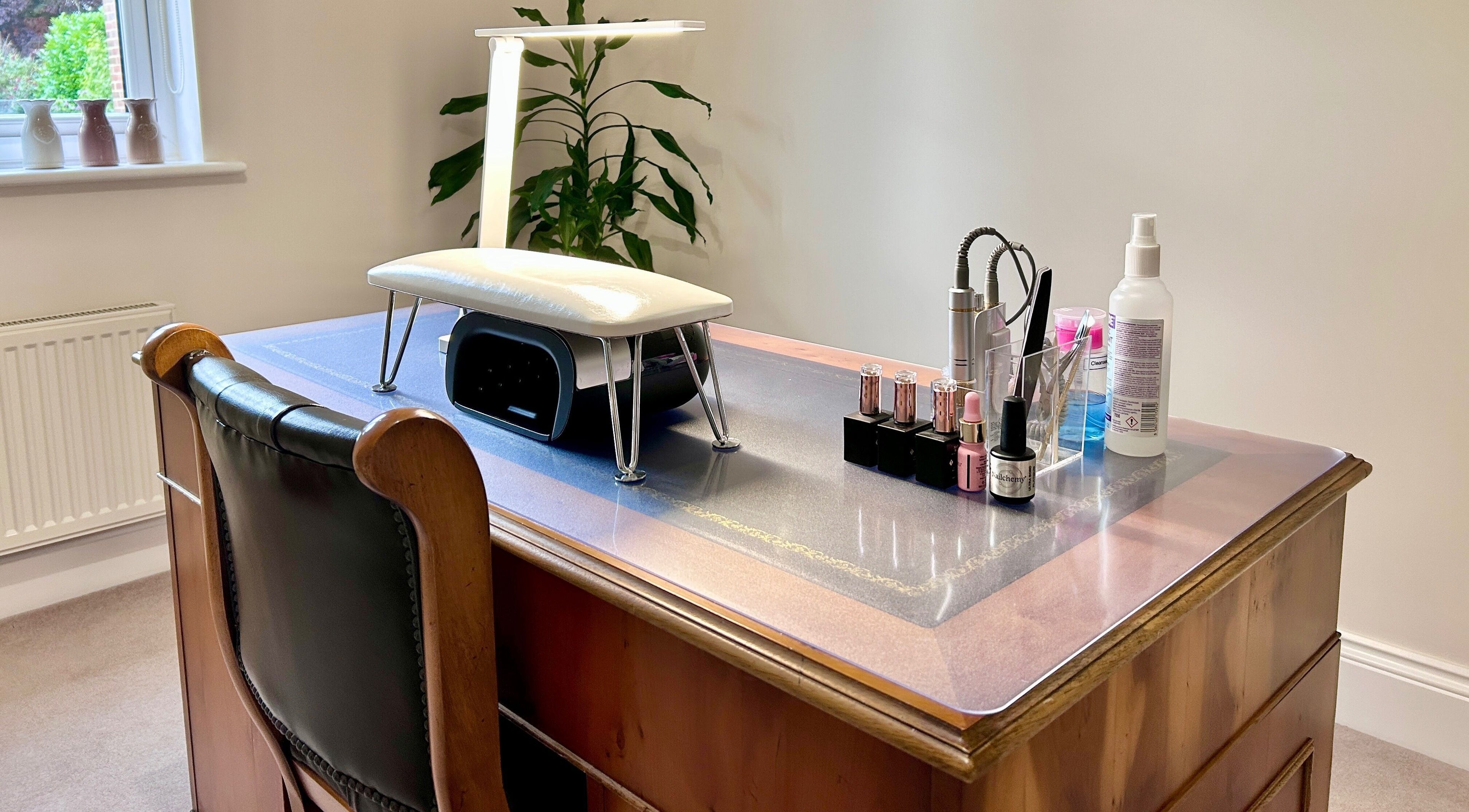 Nail station at Anna Paints Nails in Bracon Ash, England featuring polish and tools on a wooden desk.