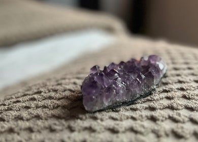 Amethyst crystal on a textured blanket at Earth Glow Holistic Wellness, Preston, England, GB.
