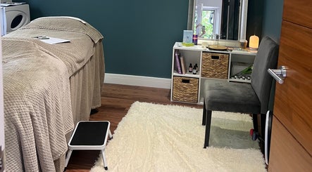 Cozy massage room at Earth Glow Holistic Wellness in Preston, England, GB with soft lighting and plush decor.