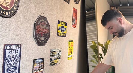 Vintage wall decor at TheGarageChair, Port Adelaide, South Australia, AU, with classic car and service signs.