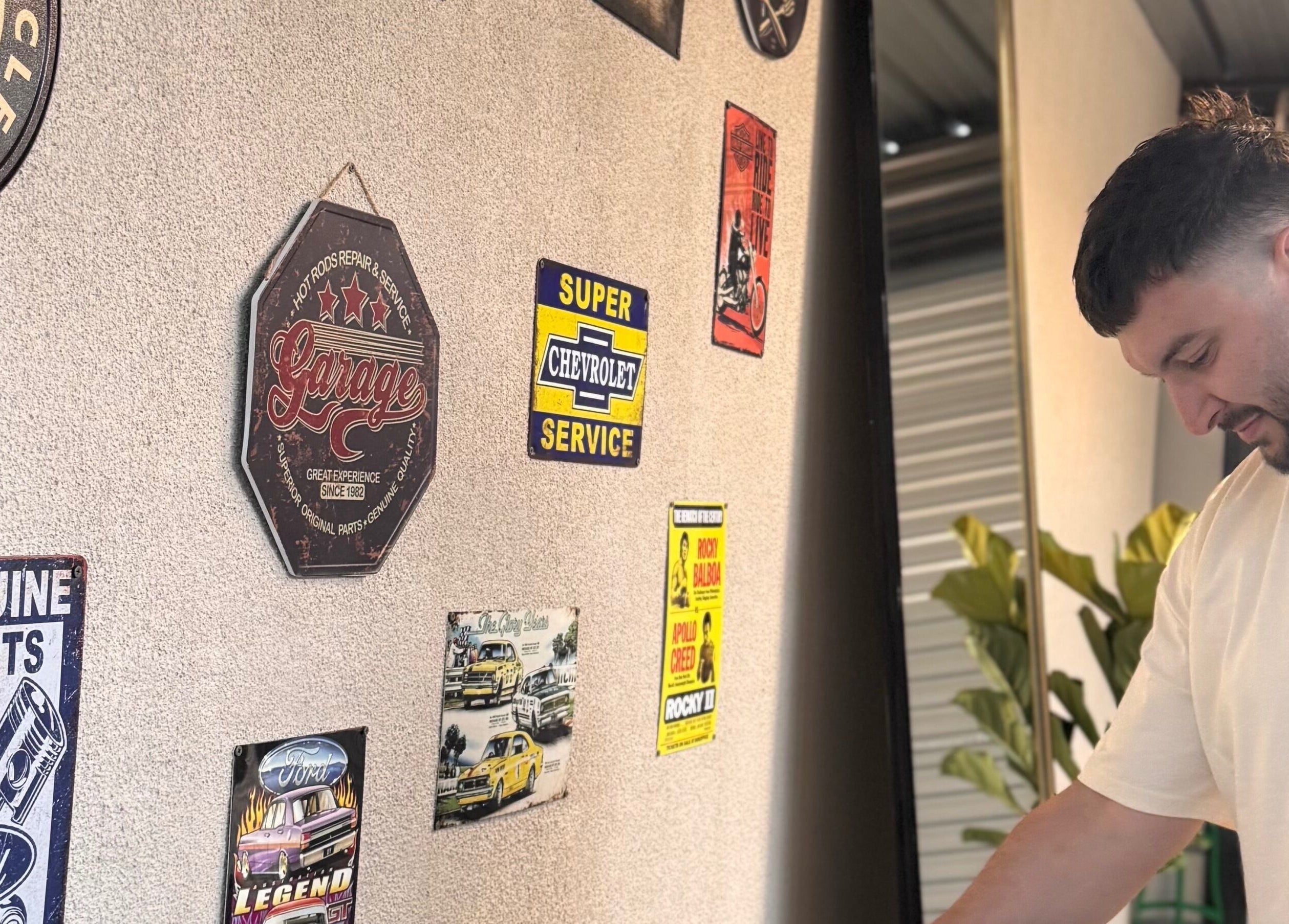 Decorative vintage signs and a person at TheGarageChair, Port Adelaide, South Australia, AU.
