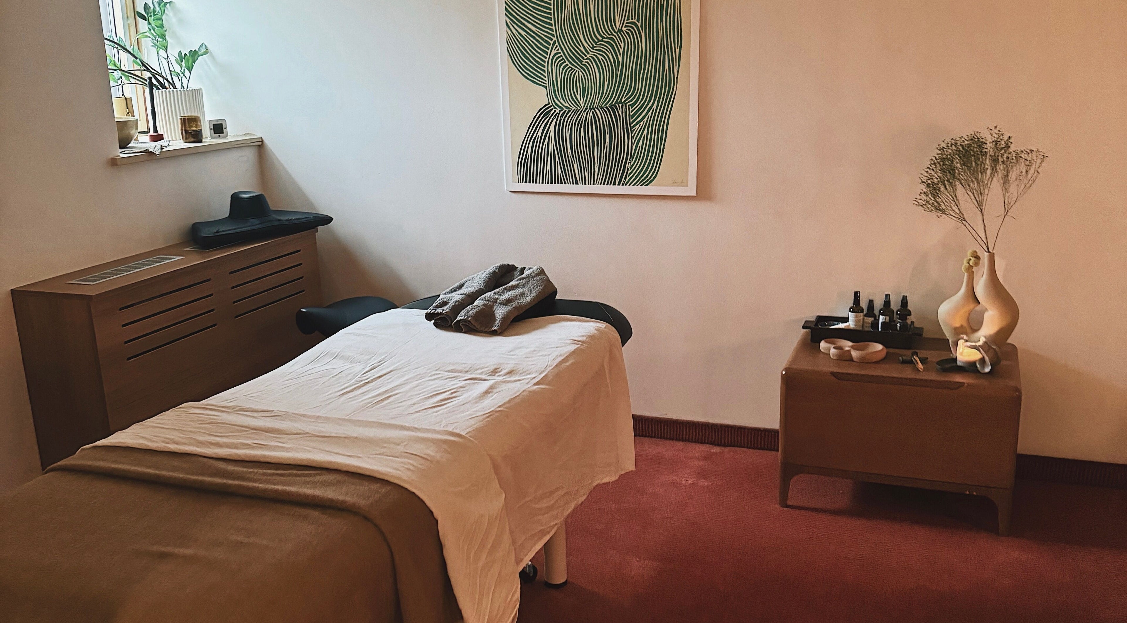 Relaxing massage room at Omai masažo studija in Vilnius, Vilniaus Apskritis, LT, featuring art and tranquil decor.