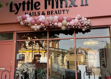 Front of Lyttle Minx II Nails & Beauty in London, England with pink decor and balloons.