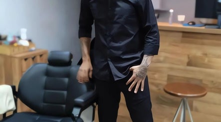 Barbeiro na Favela Barbershop em Frankfurt Am Main, Hessen, DE, ao lado de cadeira profissional.