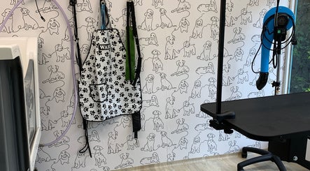 Inside Happy Hounds Dog Grooming in Wisbech Saint Mary, England featuring a dog-patterned wall and grooming tools.