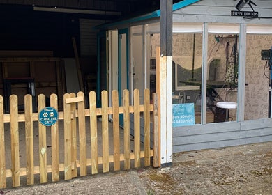 Welcoming exterior of Happy Hounds Dog Grooming in Wisbech Saint Mary, England, GB with a quaint wooden gate.