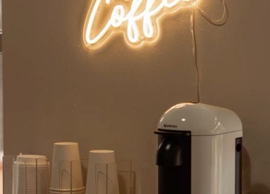 Gemütliche Kaffee-Ecke bei Lashes by Darya in Wien, Wien, AT mit leuchtendem Coffee-Schild.