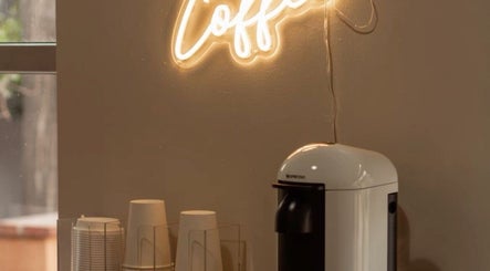 Gemütliche Kaffee-Ecke bei Lashes by Darya in Wien, Wien, AT mit leuchtendem Coffee-Schild.