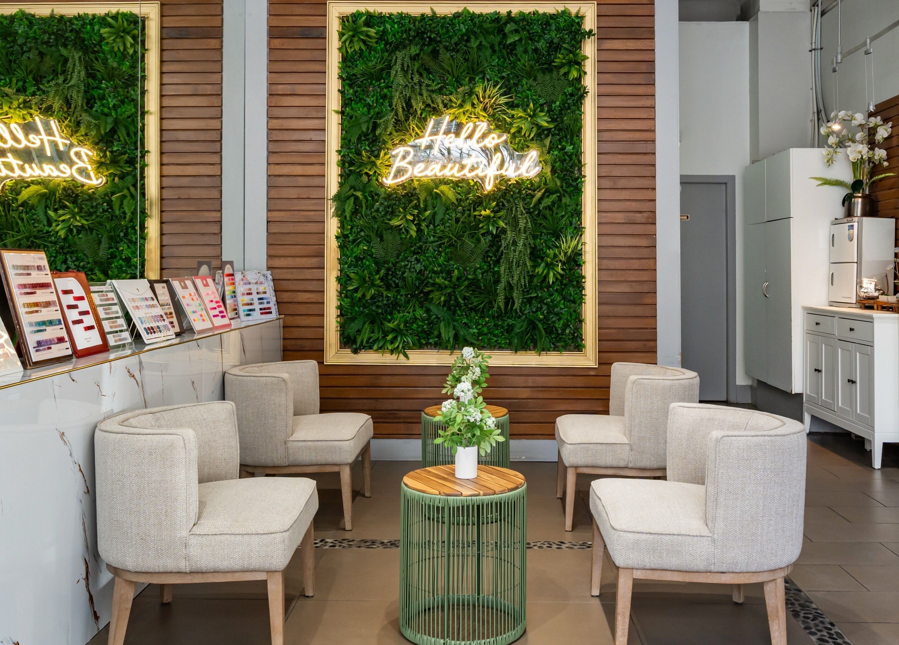 Elegant seating area at La Lotus Nails Spa, Vancouver, BC, CA with lush greenery and cozy chairs.