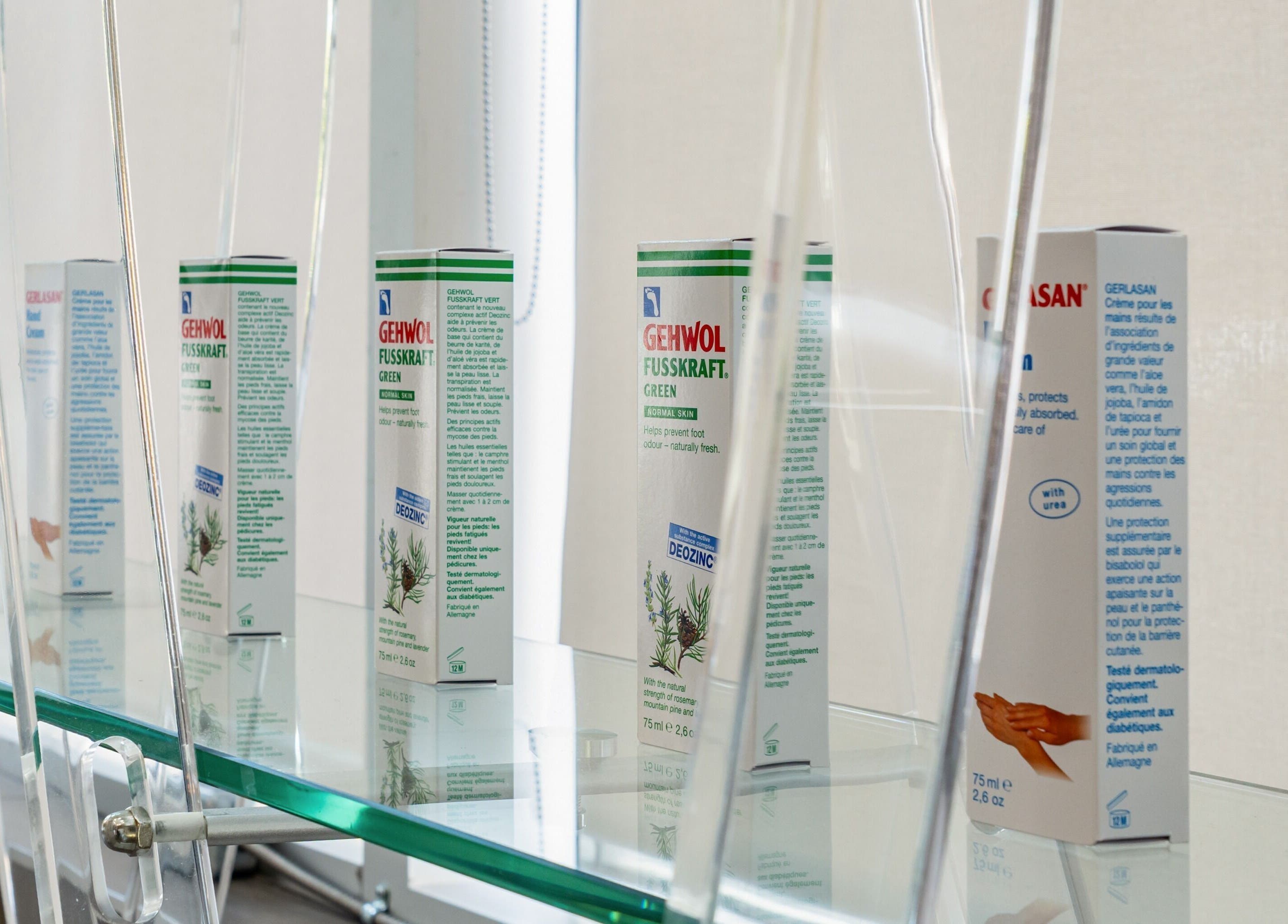 A lineup of beauty products displayed on a glass shelf at La Lotus Nails Spa, Vancouver, British Columbia, CA.