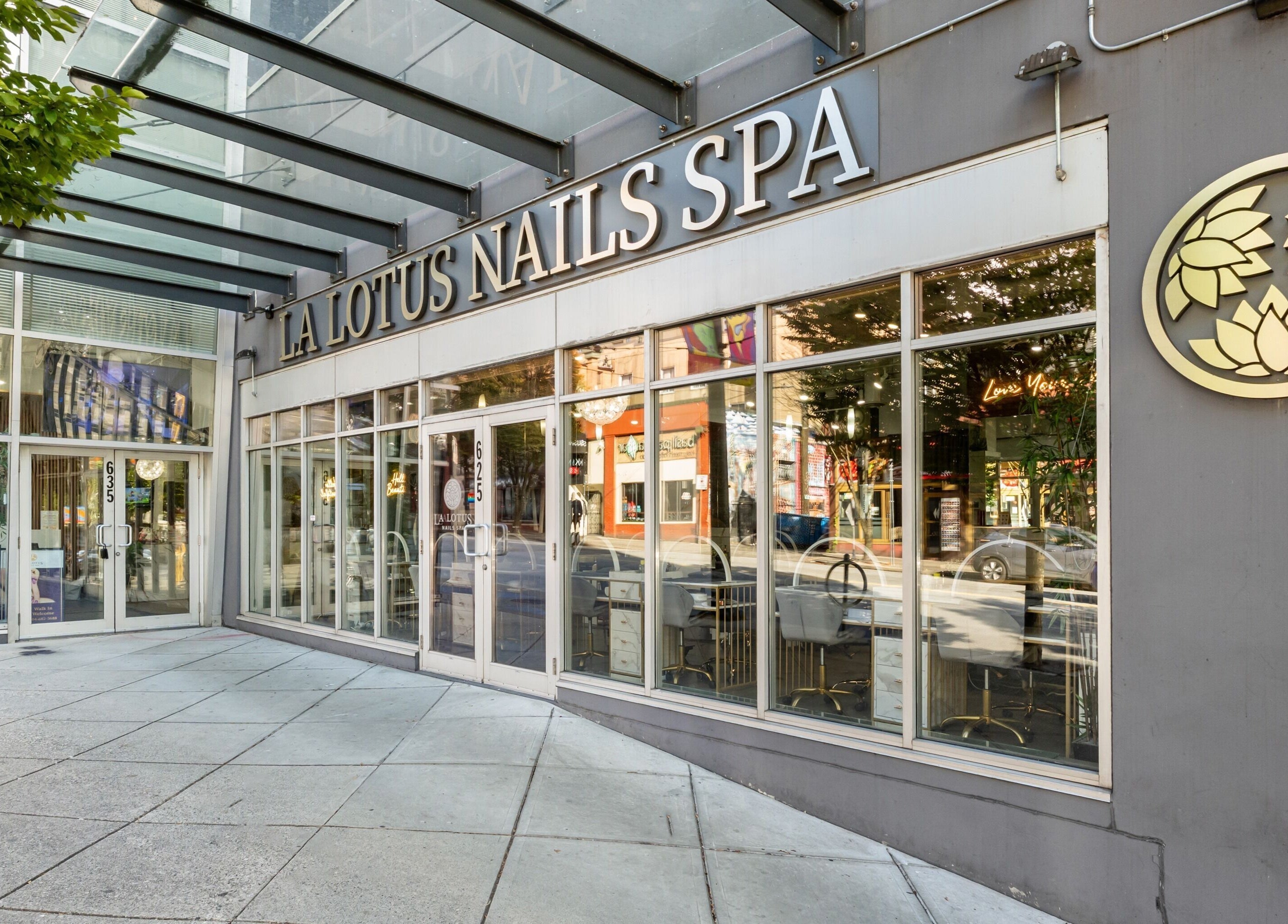 Entrance of La Lotus Nails Spa in Vancouver, British Columbia, CA with unique lotus logo and modern facade.