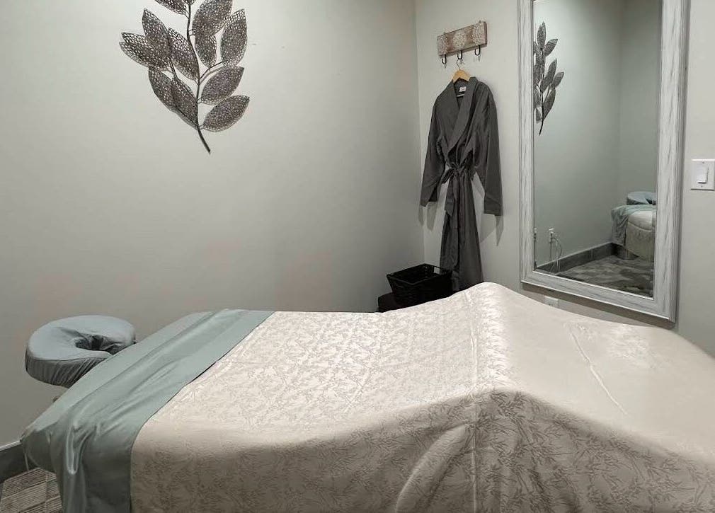 Tranquil massage room at Strength & Touch Gym in Houston, Texas, US with massage table and wall decor.