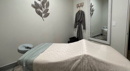Tranquil massage room at Strength & Touch Gym in Houston, Texas, US with massage table and wall decor.