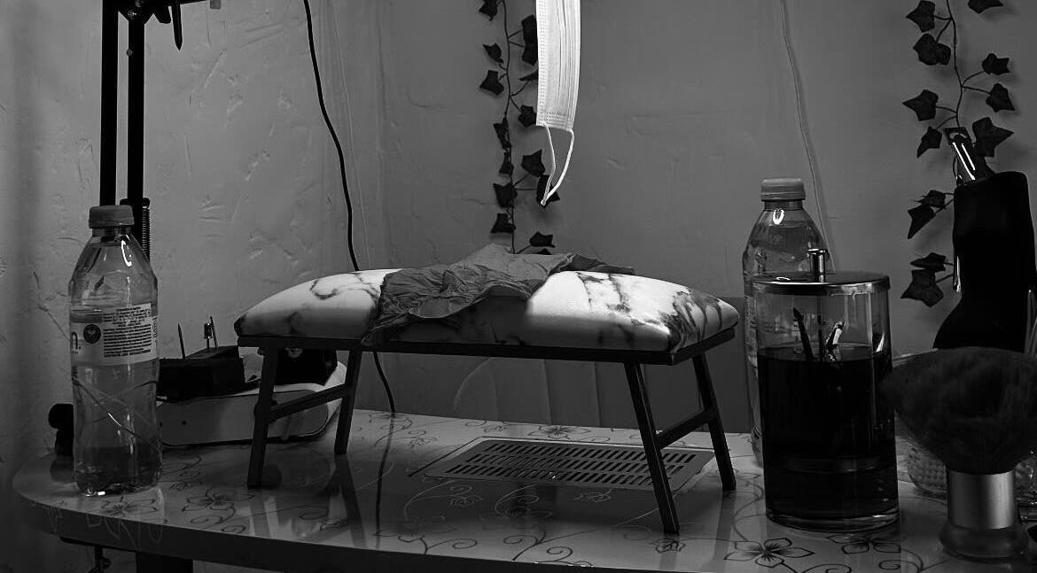 Nail station setup at The Pink Edit Co., London, England, GB featuring a cushioned rest and essential tools.