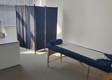 Relaxing massage room at The Reboot Room with bed and partition, Camberley, England, GB.