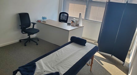 A serene therapy room at The Reboot Room, Camberley, England, GB with a massage table and desk.