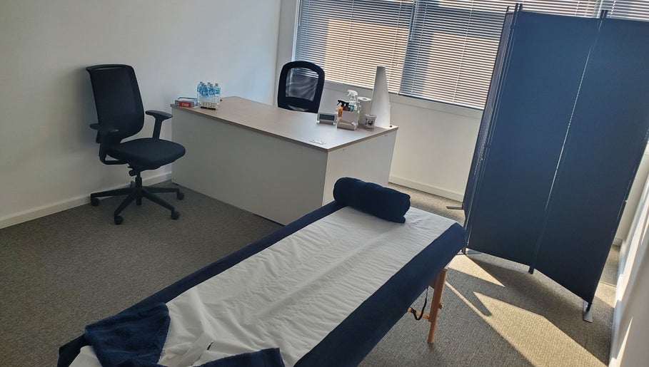 Therapy room at The Reboot Room, Camberley, England, GB with massage table, desk, and chair.