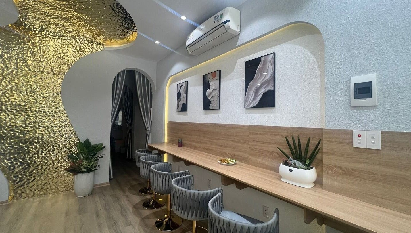 Nội thất sang trọng tại Missha Spa, Đà Nẵng, Đà Nẵng, VN, với tường vàng ánh kim và ghế hiện đại.