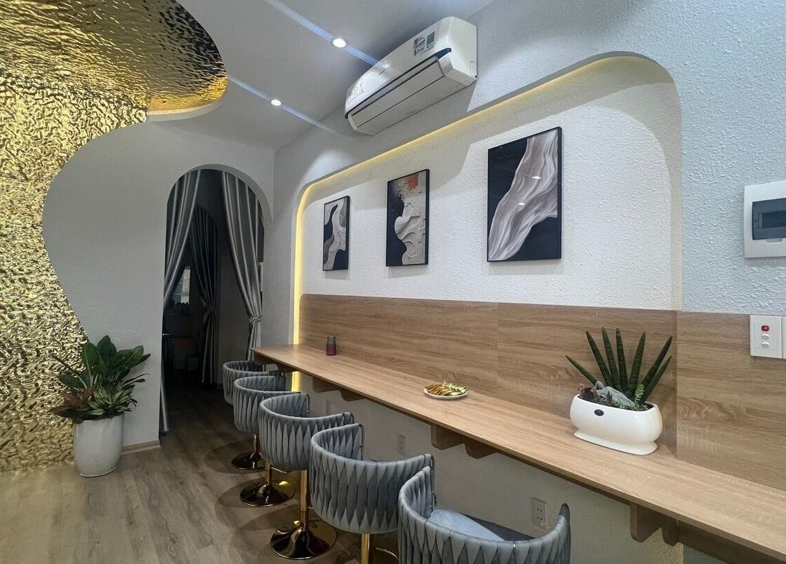 Nội thất sang trọng tại Missha Spa, Đà Nẵng, Đà Nẵng, VN, với tường vàng ánh kim và ghế hiện đại.