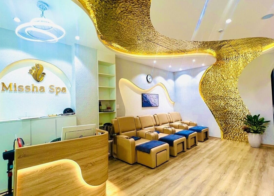 Nội thất sang trọng tại Missha Spa, Đà Nẵng, VN với ghế ngả và trang trí vàng, tạo không gian thư giãn.