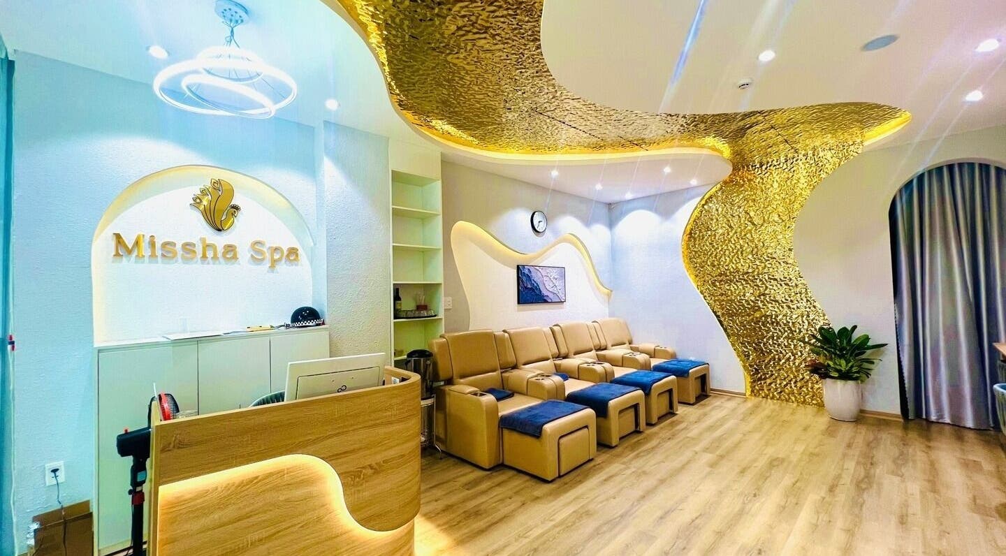Nội thất sang trọng tại Missha Spa, Đà Nẵng, VN với ghế ngả và trang trí vàng, tạo không gian thư giãn.