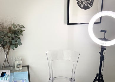 Elegant beauty setup at Refine, Oakdale, Wales, GB with a ring light, chair, and decor.