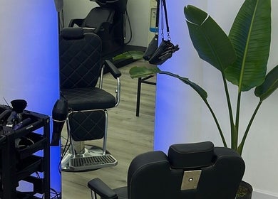 Interior moderno de Studio Style en San Nicolás De Los Arroyos con silla de peluquería y planta.