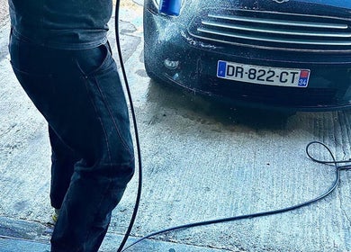 Un véhicule noir étant lavé à SUNNY WASH à Perpignan, Occitanie, FR. Service de nettoyage expert.