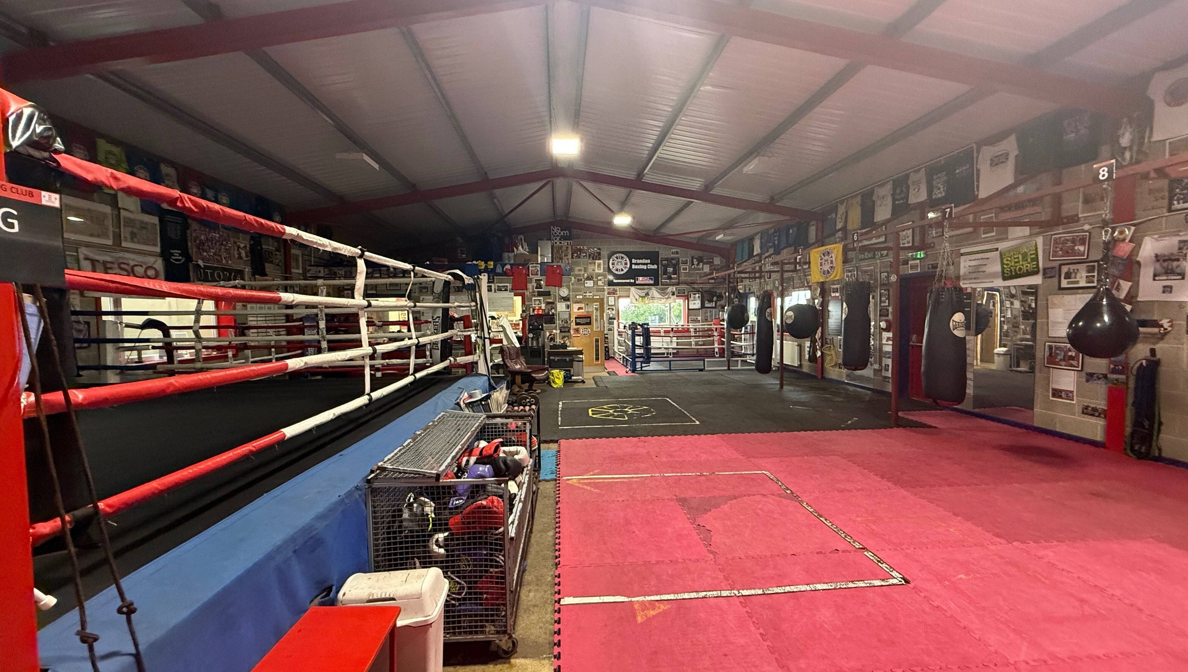Spacious boxing gym at Train With TNT in Brandon, England, GB equipped with rings and punching bags.