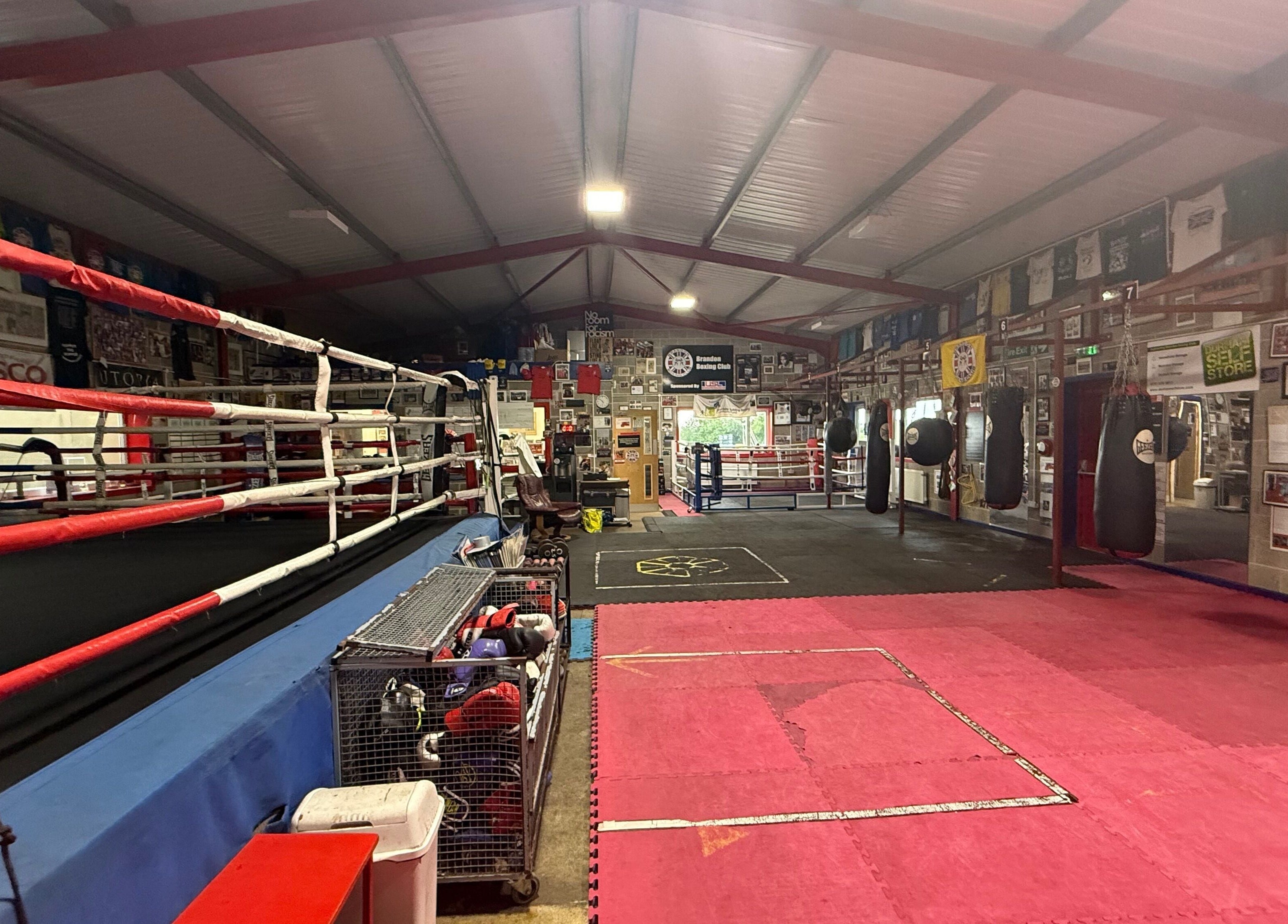 Spacious boxing gym at Train With TNT in Brandon, England, GB equipped with rings and punching bags.