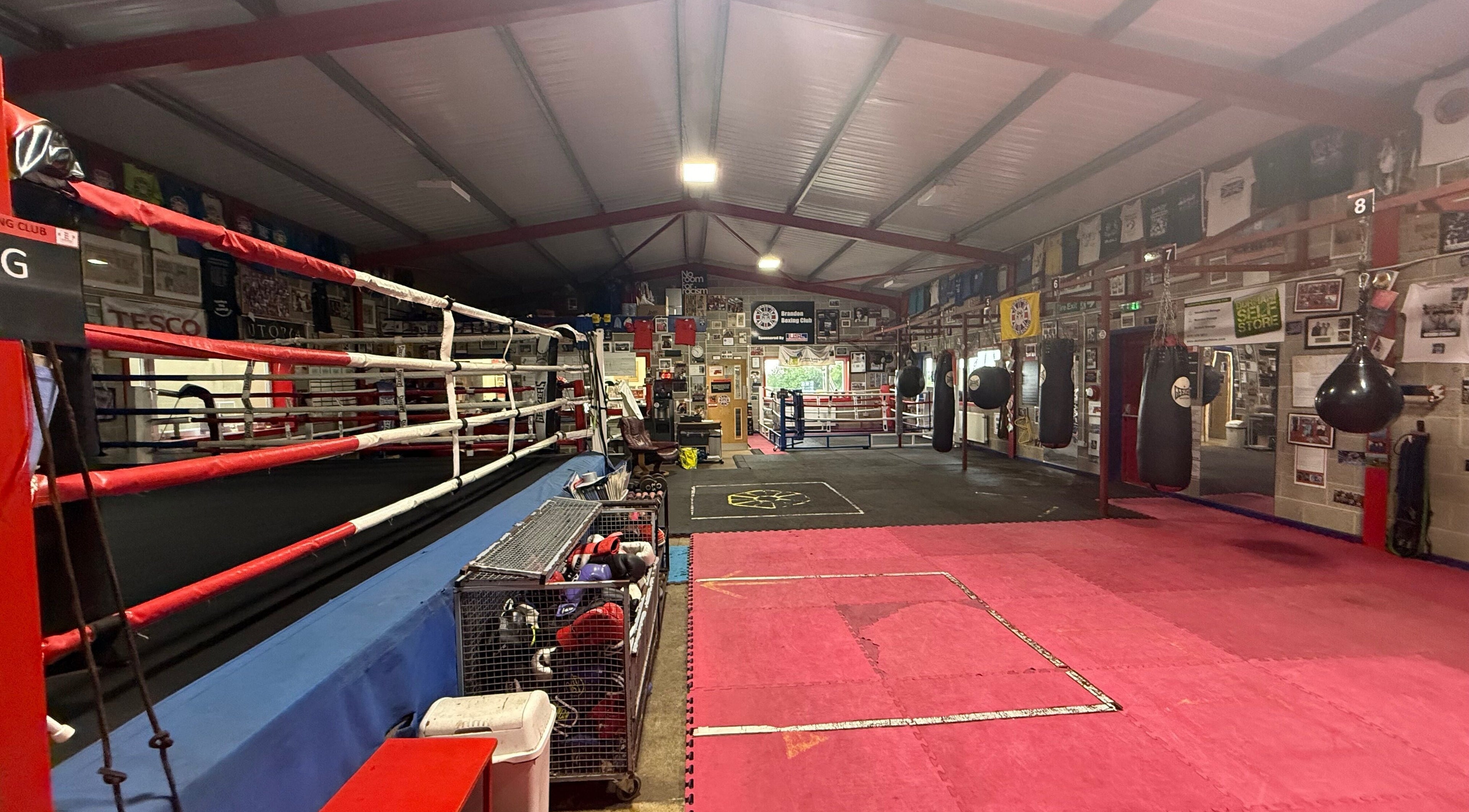 Spacious boxing gym at Train With TNT in Brandon, England, GB equipped with rings and punching bags.