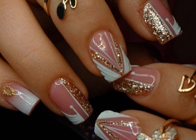 Diseño elegante de uñas en Babys_Nails_Caracas, Caracas, VE, con brillo dorado y detalles artísticos.