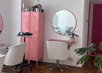 Interior moderno y elegante de Taller Capilar en Concepción, Bío Bío, CL con espejos redondos y detalles en rosa.