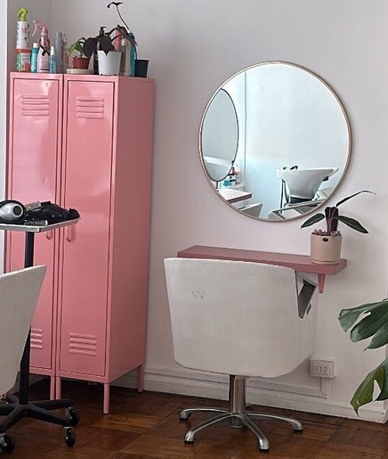 Interior moderno y elegante de Taller Capilar en Concepción, Bío Bío, CL con espejos redondos y detalles en rosa.